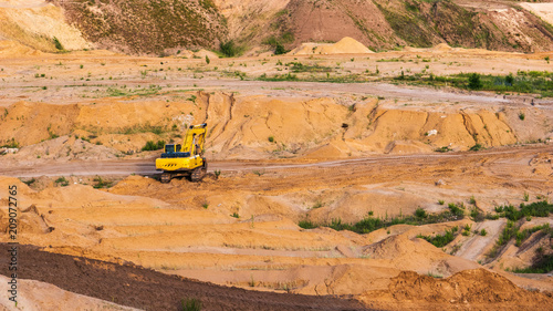 Hydraulic excavator works on sand limestone quarry, industrial heavy machinery