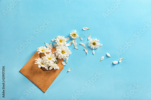 Fototapeta Naklejka Na Ścianę i Meble -  Open mail envelope with flowers on color background