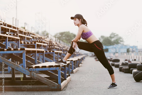 Fototapeta Naklejka Na Ścianę i Meble -  Women stretching for warming up before running or working out. Fitness and healthy lifestyle concept.