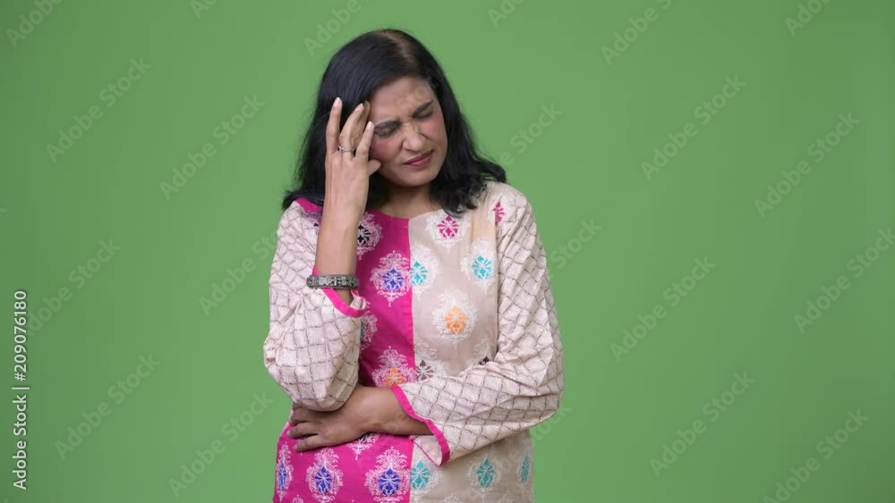 Mature stressed Indian woman having headache while getting bad news Mature stressed Indian woman having headache while getting bad news