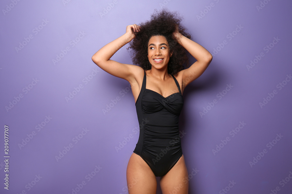 Beautiful African-American woman in swimming suit on color background Beautiful African-American woman in swimming suit on color background