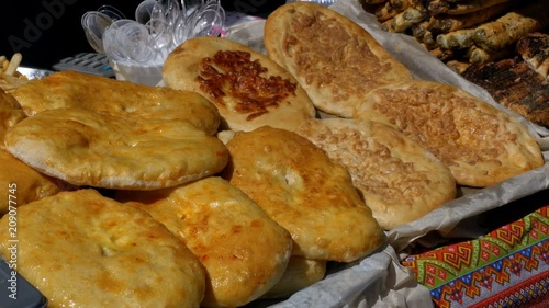 Georgian pastries khachapuri at the counter of the store. A variety of food lies in the container on the table. photo