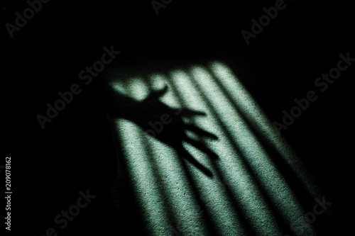 Creepy hand shadow on window blinds.