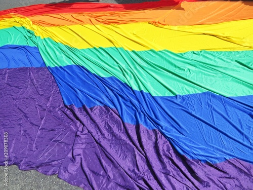 Big Rainbow LGBT Flag Laying on Pavement During Parade