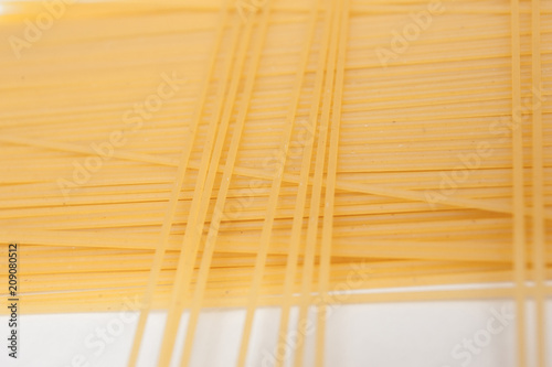 Yellow long spaghetti on black background. Thin pasta arranged in rows. Yellow italian pasta. Long spaghetti. Raw spaghetti wallpaper. Thin spaghetti. Food background concept. 