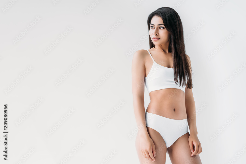 young mixed race woman in white lingerie looking away isolated on gray background young mixed race woman in white lingerie looking away isolated on gray background