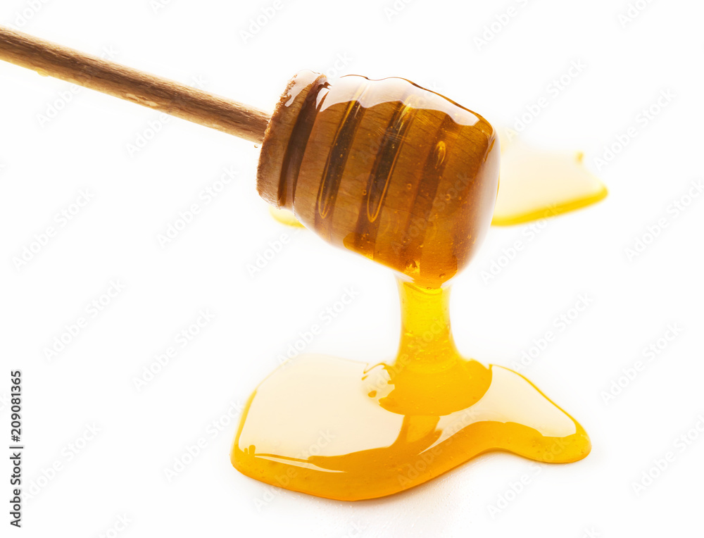 Honey and wooden dipper isolated on white Honey and wooden dipper isolated on white