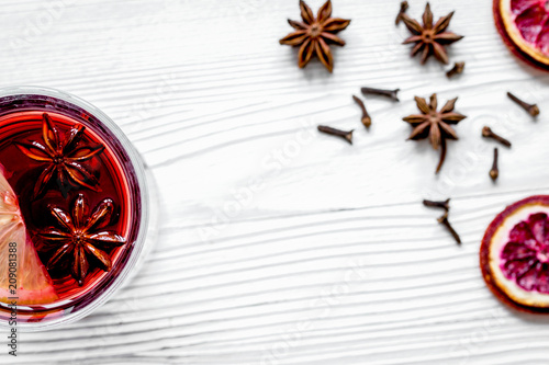 mulled wine with spices in cup wooden background top view