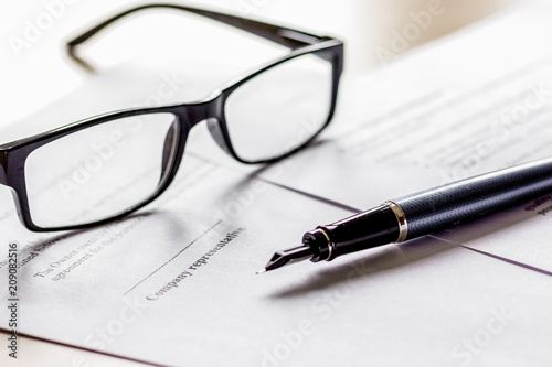 Signing the contract with pen and glasses in business work on of