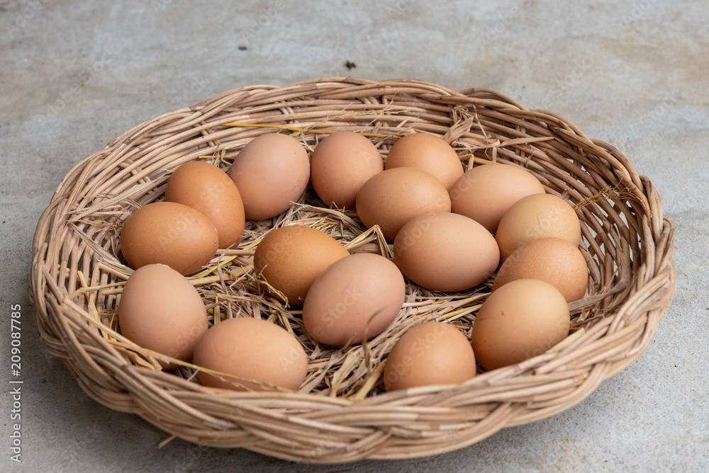 Many eggs in a basket on a cement floor. Many eggs in a basket on a cement floor.