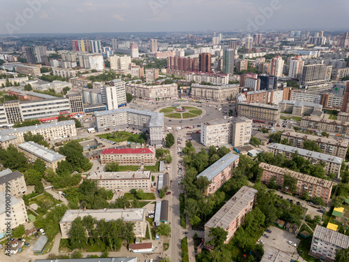 View from the air on old and new russian buildings near the circular motion in the city with a lot of cars. Russian streets, Novosibirsk.