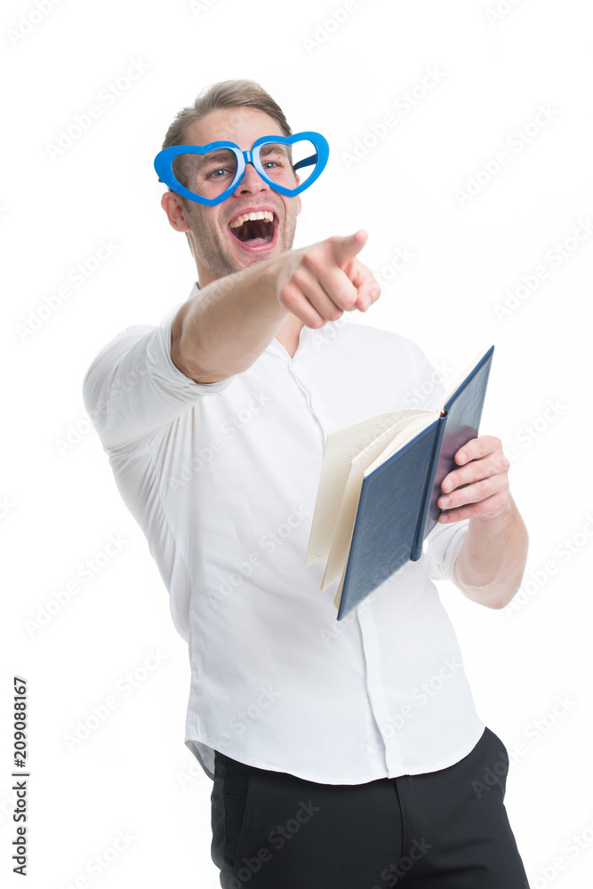 Sincere laugh. Man handsome young pointing forward and laughing. Man happy smiling blonde blue eyes in heart shaped eyeglasses having fun. Guy with book laughing isolated white background