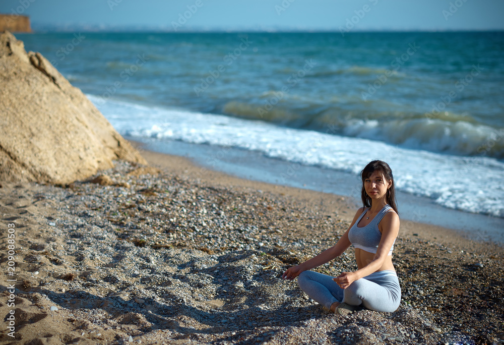 Sexy fit brunette posing near the sea Sexy fit brunette posing near the sea