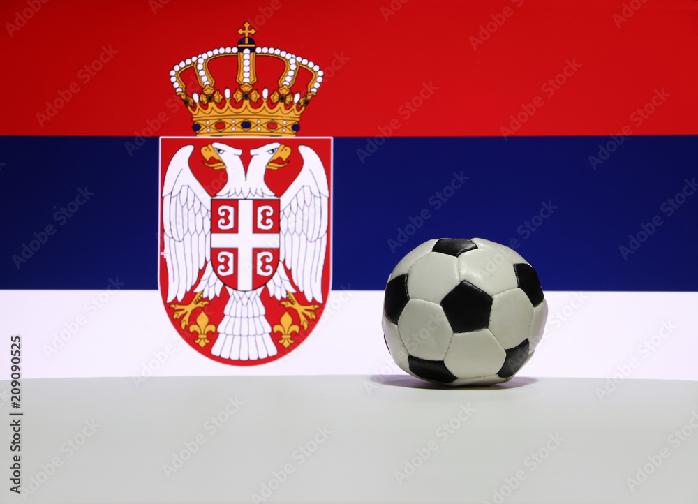 Small football on the white floor with white blue and red color, eagle and crown picture of Serbian nation flag background. The concept of sport. Small football on the white floor with white blue and red color, eagle and crown picture of Serbian nation flag background. The concept of sport.