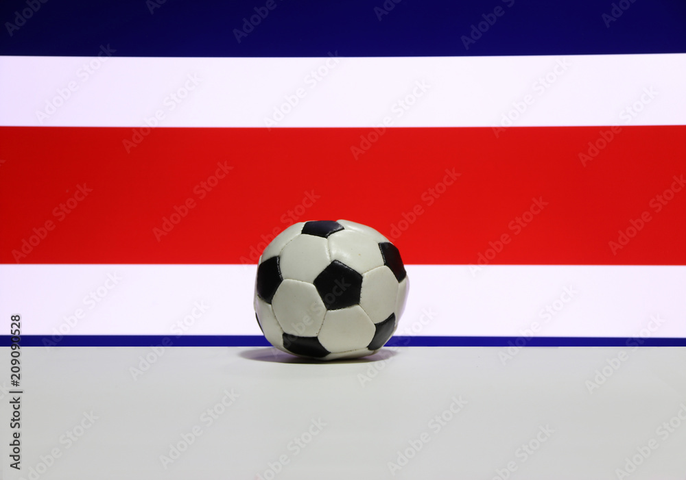 Fototapeta premium Small football on the white floor with white red and blue color of Costa Rican nation flag background. The concept of sport.