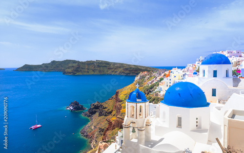 Oia town on Santorini island, Greece. Traditional and famous houses and churches with blue domes over the Caldera, Aegean sea © gatsi