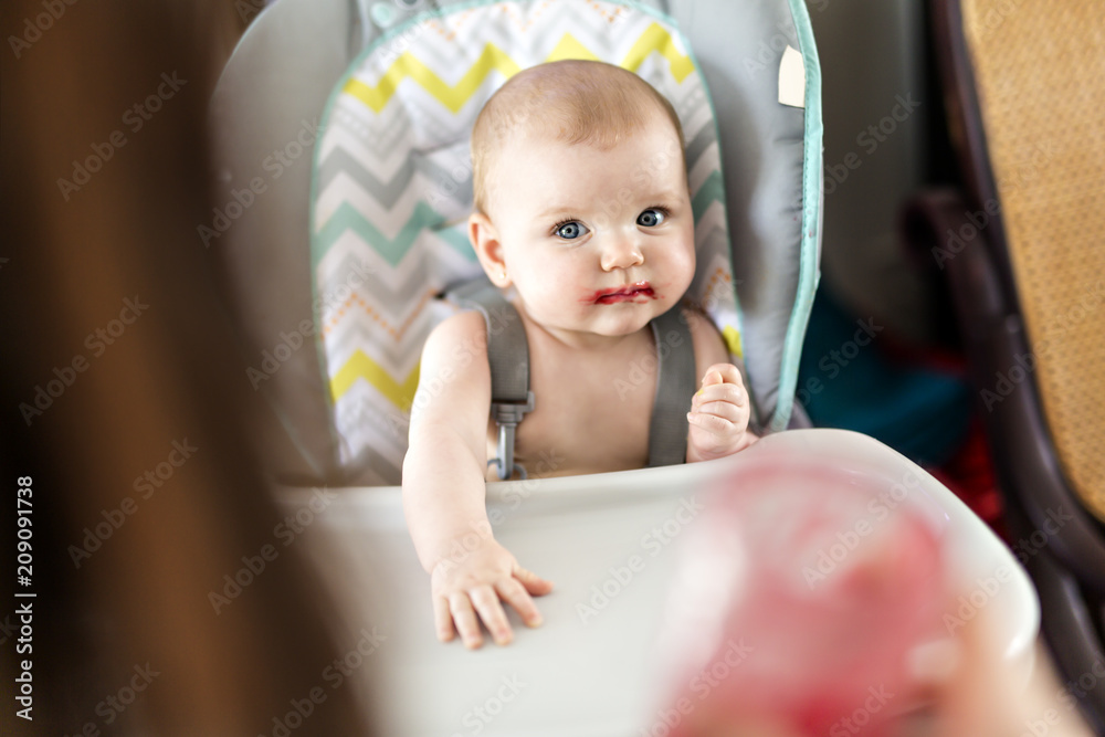 Mother Feeding Baby girl In High Chair Mother Feeding Baby girl In High Chair