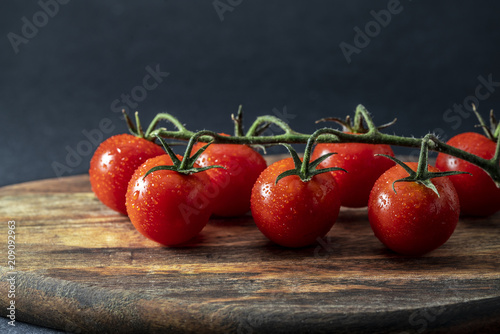 Tomatoes on the vine on wooden board