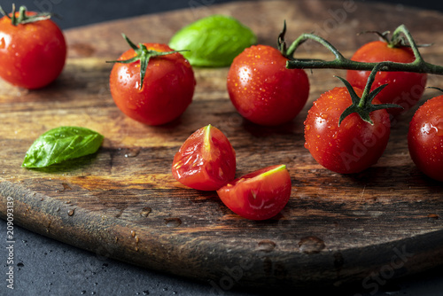 Tomatoes on the vine on wooden board