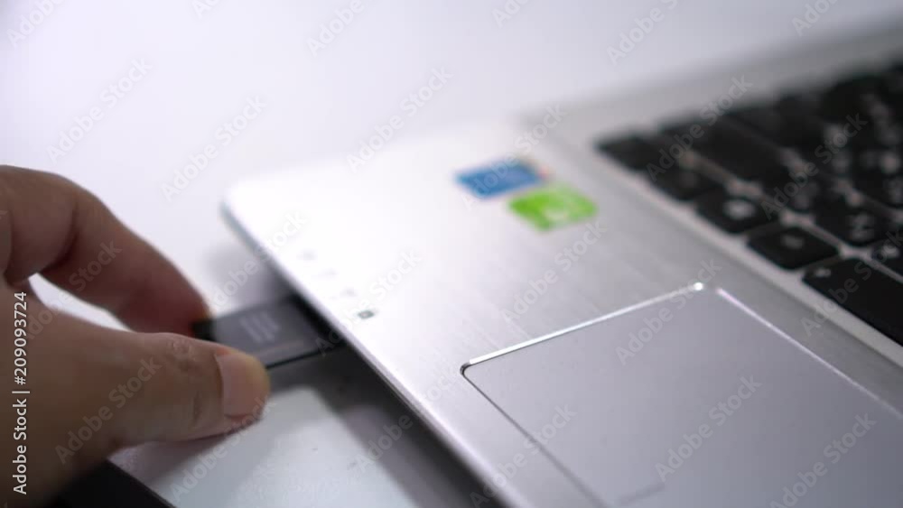 User plugging in SD memory card into laptop computer ready for file