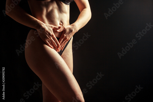 Young beautiful girl naked isolated on a black background