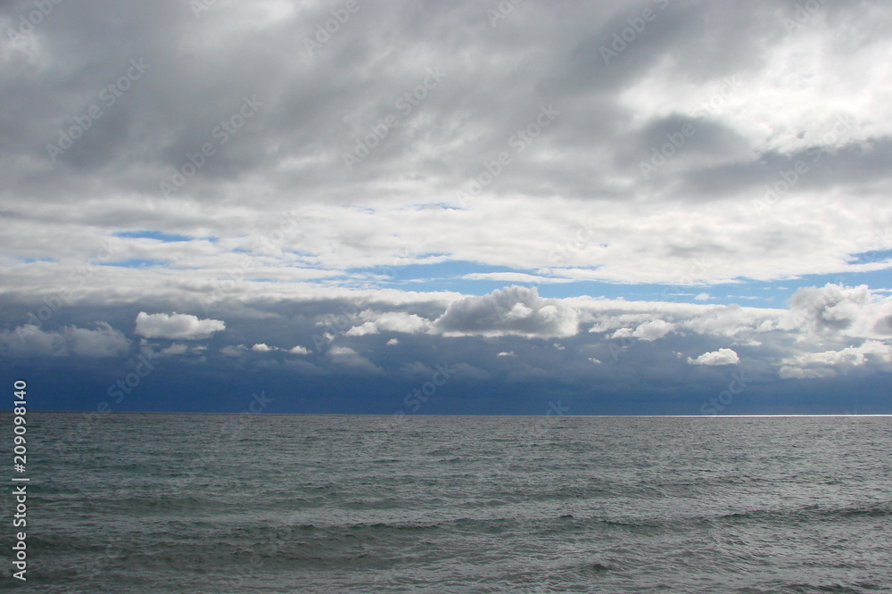 a panorama of the autumn cloudy Crimean sky above the gentle waves of the Black Sea.