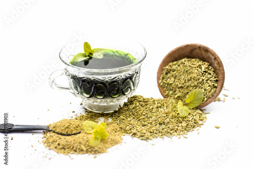 Raw fennel with its powder and its beneficial tea or extract in a transparent cup isolated on white. photo