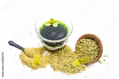 Raw fennel with its powder and its beneficial tea or extract in a transparent cup isolated on white. photo