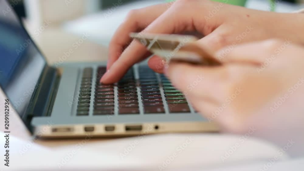 Female hands typing credit card number on laptop computer keyboard. Woman making online purchase. Online payment service. Close up of woman hands hold credit card and using laptop for online shopping Female hands typing credit card number on laptop computer keyboard. Woman making online purchase. Online payment service. Close up of woman hands hold credit card and using laptop for online shopping