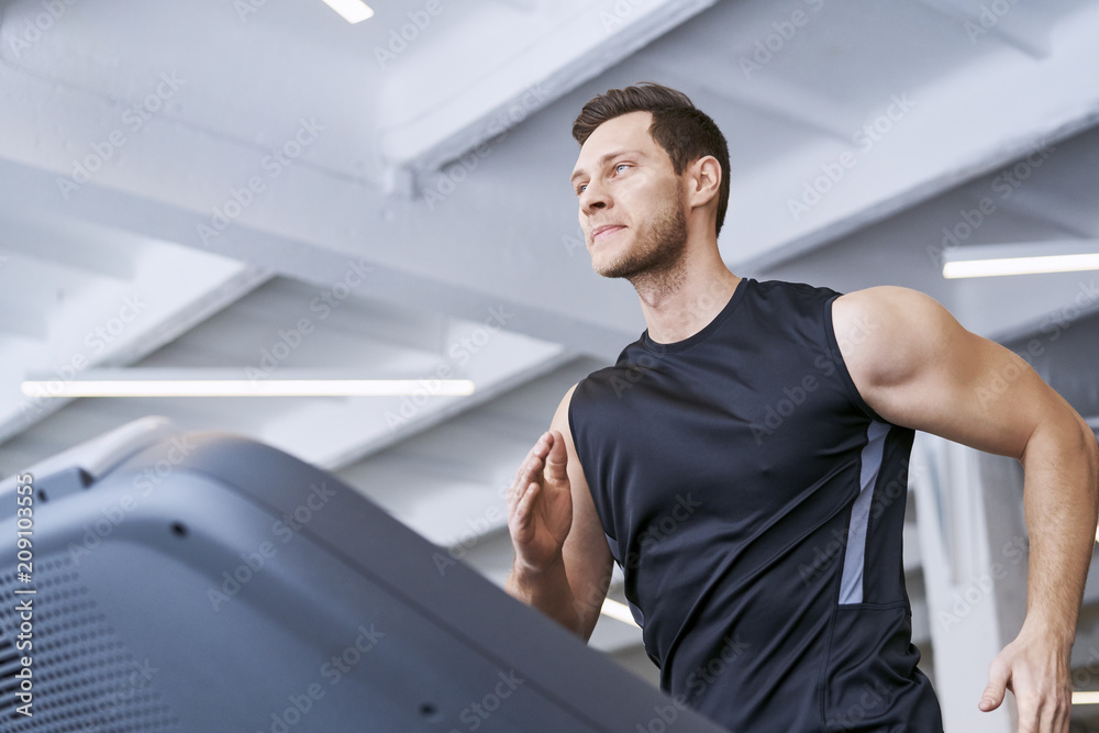 Man running on treadmill at gym Man running on treadmill at gym