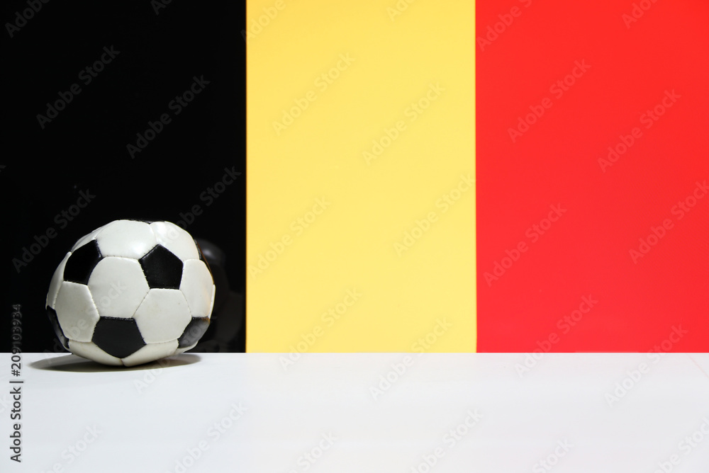 Small football on the white floor with black yellow and red color of Belgian nation flag background. Small football on the white floor with black yellow and red color of Belgian nation flag background.