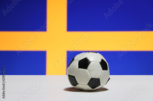 Small football on the white floor with out focus blue and yellow color of Swedish nation flag background.