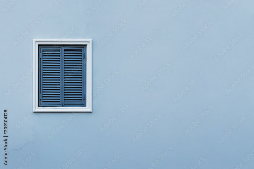 Fototapeta premium Blue wall of the house with a closed window left and details.