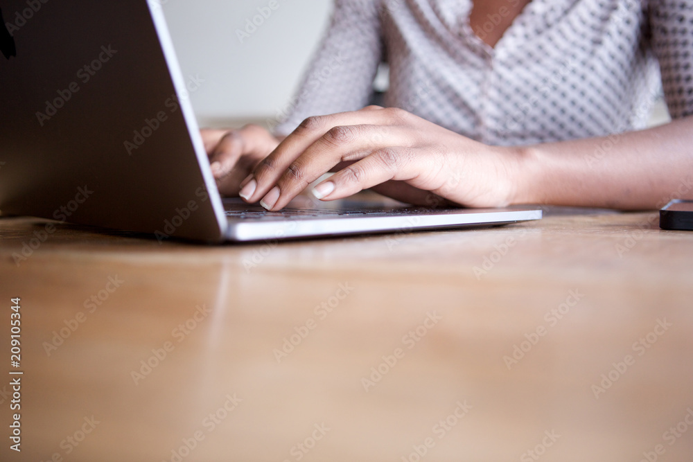 Close up partial woman sitting and typing on laptop computer in home office Close up partial woman sitting and typing on laptop computer in home office