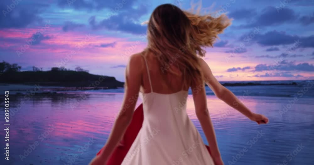 Couple of pretty girls in summer dresses dancing on the beach at sunset, Cheerful young white women spinning around and having fun in a beautiful beach setting, 4k