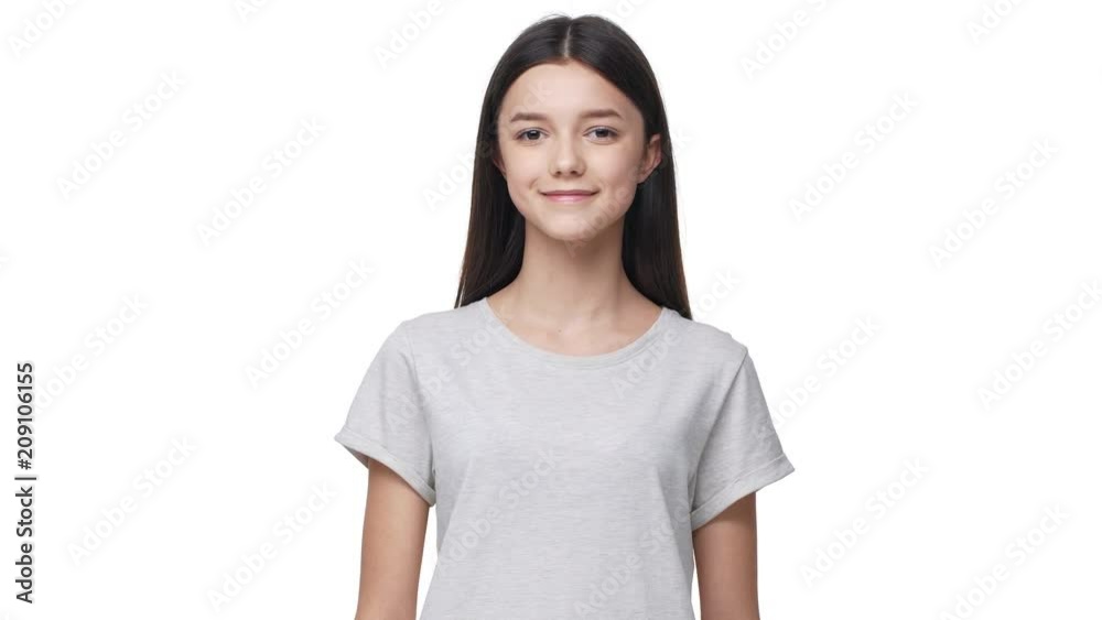 Portrait of lop-eared caucasian woman with long dark hair in basic t-shirt looking at camera with beautiful smile, isolated over white background in studio. Concept of emotions Portrait of lop-eared caucasian woman with long dark hair in basic t-shirt looking at camera with beautiful smile, isolated over white background in studio. Concept of emotions