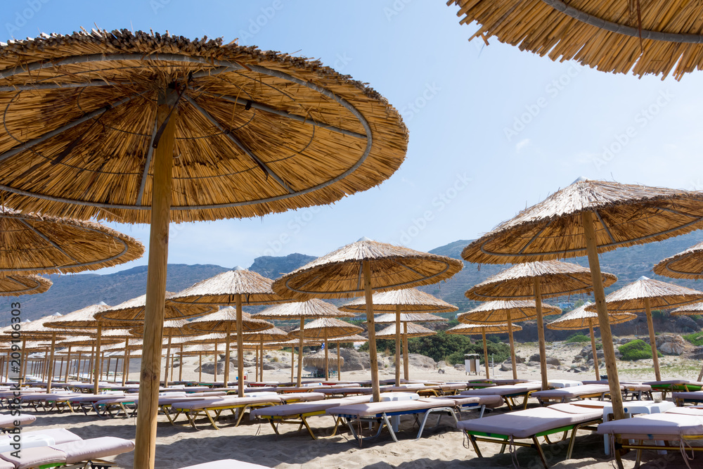 straw parasols on the beach of Falassarna, Crete