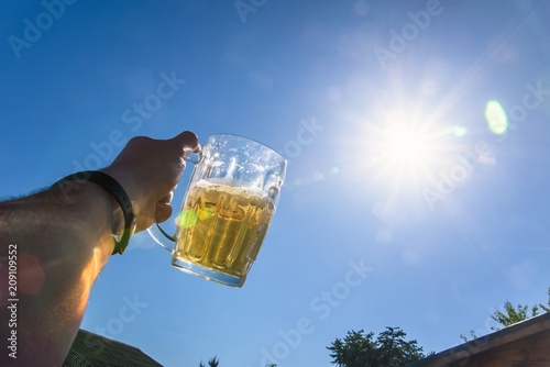Glass of beer in hand photo