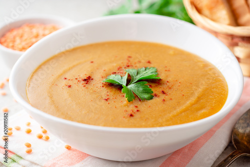 Red lentil cream soup on gray stone background photo