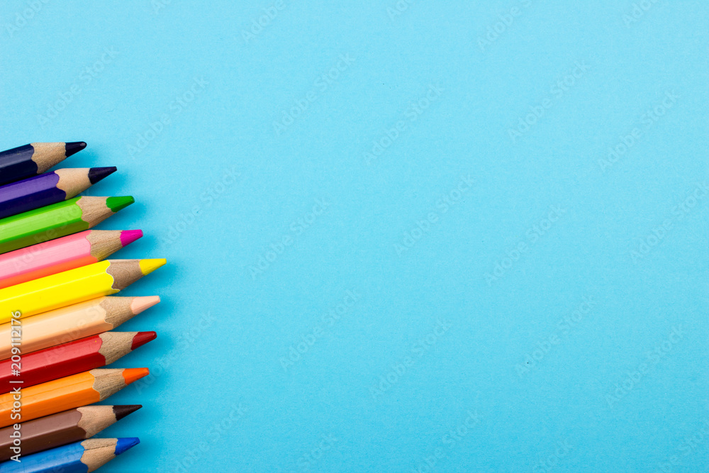 Fototapeta premium Pencils set on blue tone color paper. Empty space for text and design. Minimalism concept.