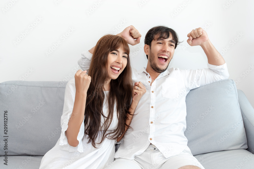 Young Couple Football Fans Watching Soccer on TV and Celebrating Victory at Living Room - Lifestyle Concept Young Couple Football Fans Watching Soccer on TV and Celebrating Victory at Living Room - Lifestyle Concept