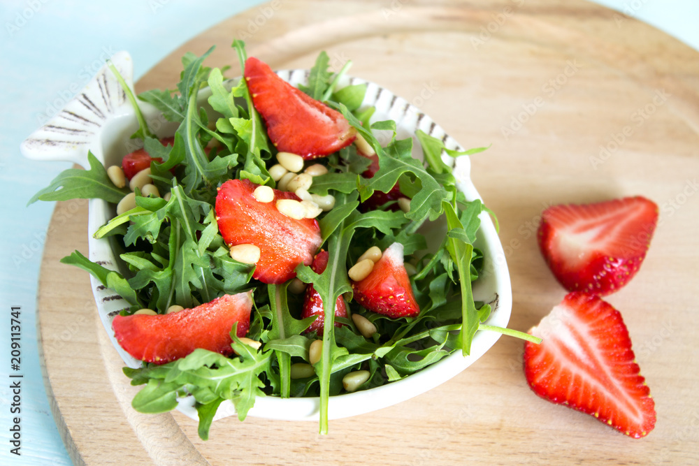 Salad of arugula and strawberries with pine nuts. Top view. Copy space. Salad of arugula and strawberries with pine nuts. Top view. Copy space.