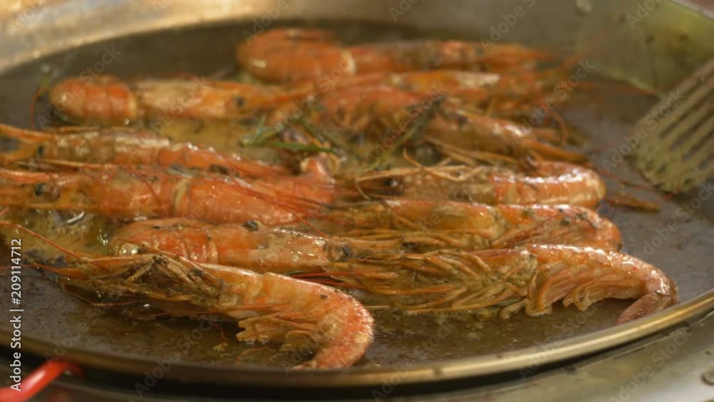 Grilled shrimp on a barbecue. The hand turns the shrimp's iron scoop to the grill. Fried seafood on a barbecue. fried shrimp at a street food festival. Grilled Seafood Preparation Grilled shrimp on a barbecue. The hand turns the shrimp's iron scoop to the grill. Fried seafood on a barbecue. fried shrimp at a street food festival. Grilled Seafood Preparation