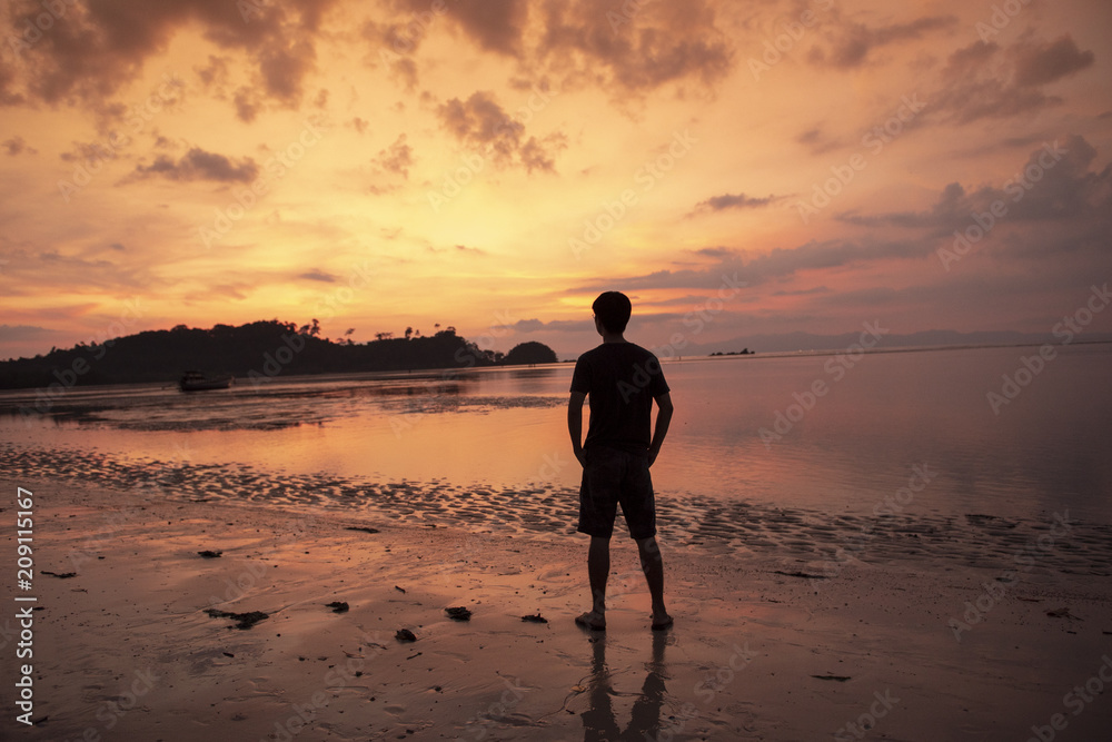 Naklejka premium A man thoughtful on beach at sunset