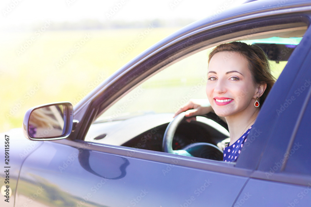 lovely smiling girl driving a car. Photo of the girl at the wheel of the car