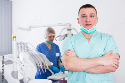 Male dentist with arms crossed in dental office