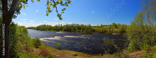 Spring panorama with a lazy river and rapids