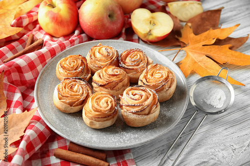 Fototapeta Naklejka Na Ścianę i Meble -  Plate with apple roses from puff pastry on wooden table