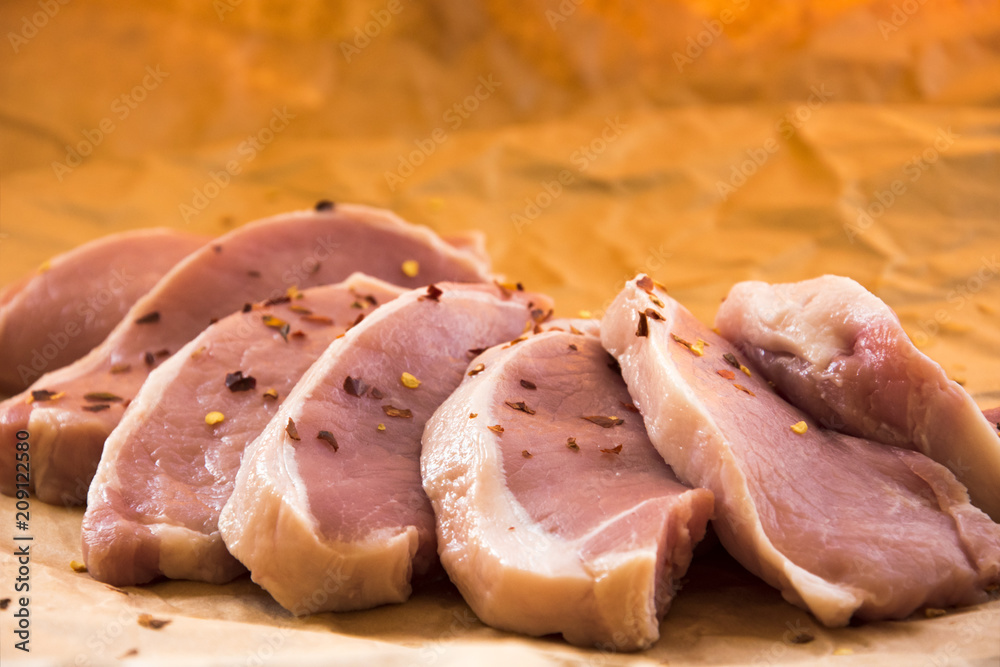 Fresh raw pork chops on a cutting board. Arrangement on the wrapping paper Fresh raw pork chops on a cutting board. Arrangement on the wrapping paper
