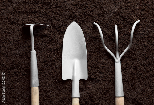 Flat lay composition with gardening tools on soil